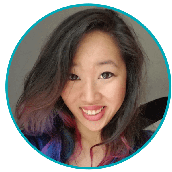 Smiling person with long, dark hair and colorful highlights, set in a circular teal frame.